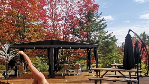 A yoga mat on a wooden deck with a gazebo in the background.