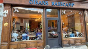 A restaurant named OISANS BASECAMP with large windows and ornate decorations. - Hotel Oberland (Le Bourg-d'Oisans)