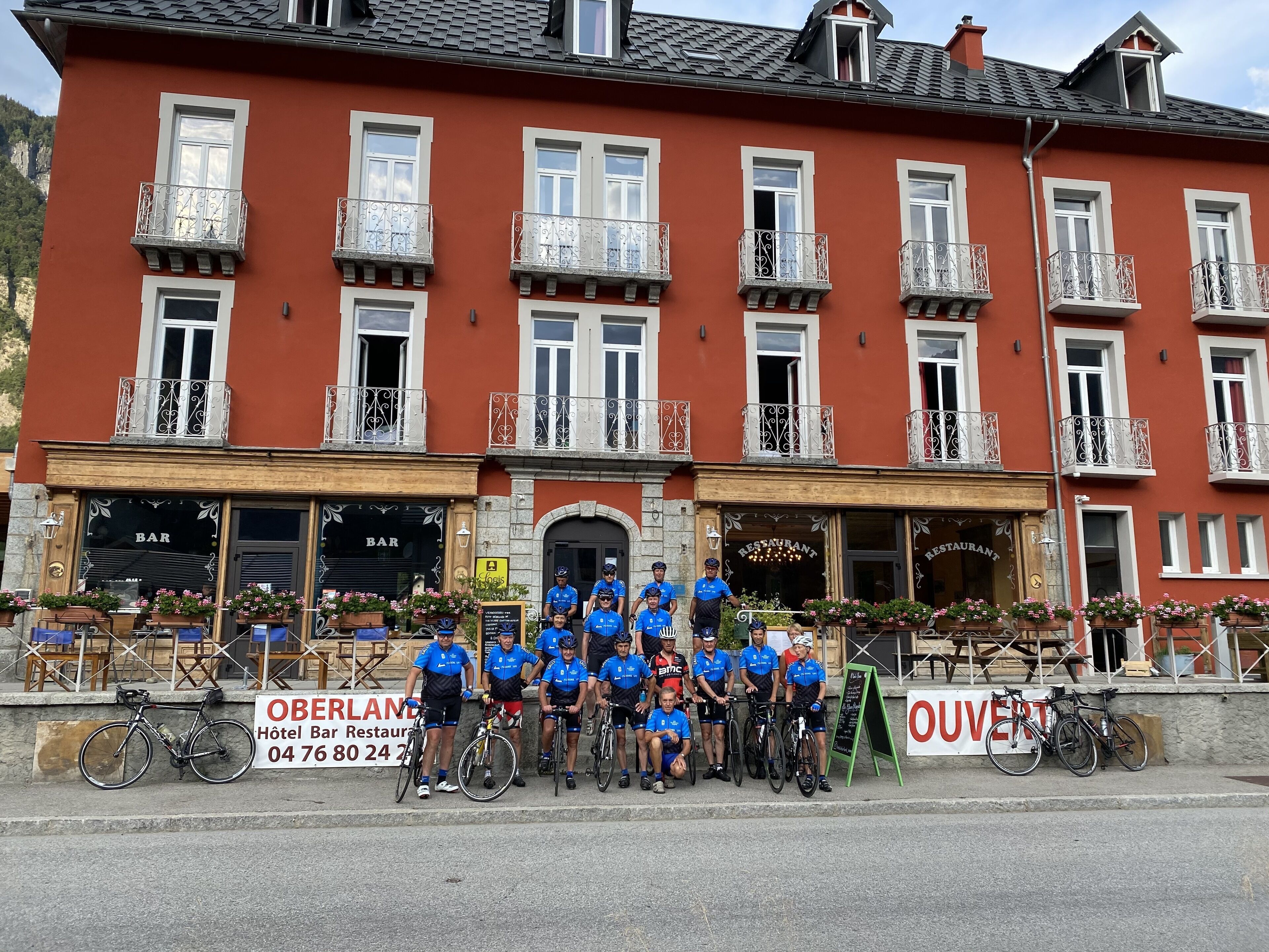 A hotel with a bar and restaurant on the ground floor, multiple balconies, and bicycles parked outside.