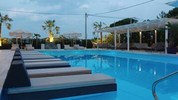 Una piscina al aire libre de temporada, sillones reclinables de piscina