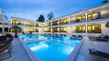 Una piscina al aire libre de temporada, sillones reclinables de piscina
