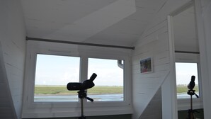 A room with large windows, a telescope, and a painting on the wall. - House with bay view in the heart of the city (Saint-Valery-sur-Somme)