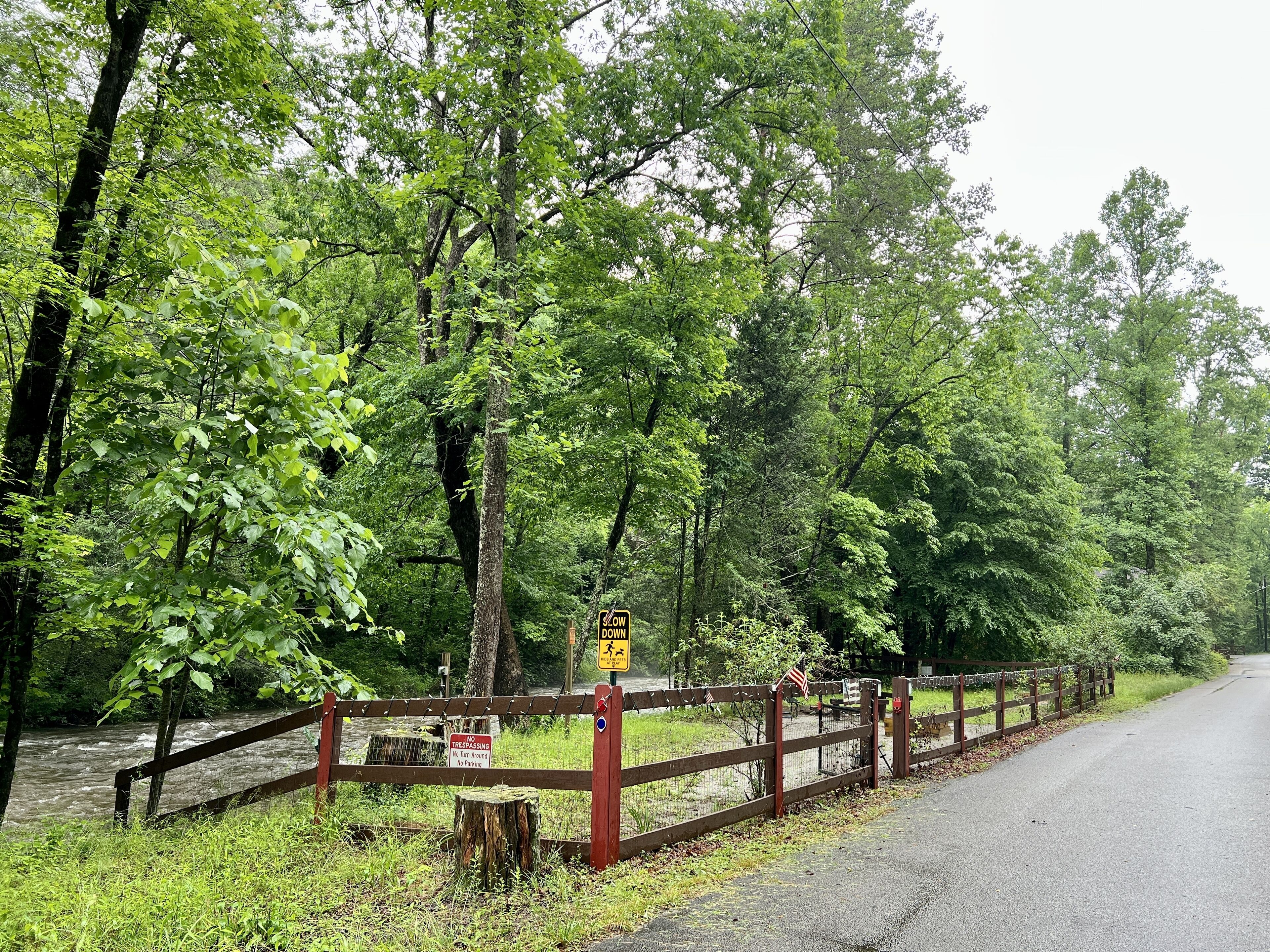 A wooden fence with a sign indicating no trespassing and no parking.