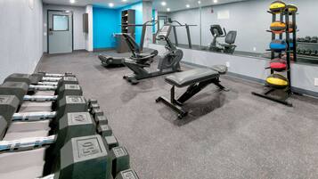 A gym with weightlifting equipment, treadmills, and exercise bikes.