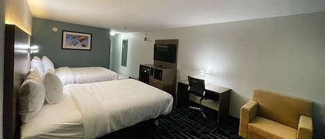 A hotel room with a bed, a desk, a chair, and a TV.