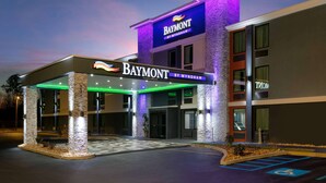 En hotellentrén med ett överbyggt område, en skylt med texten ”Baymont by Wyndham” och en parkeringsplats med platser reserverade för rörelsehindrade.