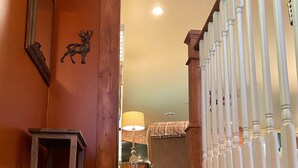 A staircase with wooden railings and a carpeted landing. - Enjoy Nature In Style! (Jamestown)