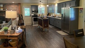 A modern kitchen with dark cabinets, stainless steel appliances, and a central island. - Enjoy Nature In Style! (Jamestown)