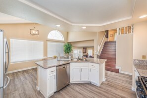 A modern kitchen with white cabinets, a dishwasher, and a granite countertop. - Incredible Home can accommodate 12 guests! (Henderson)