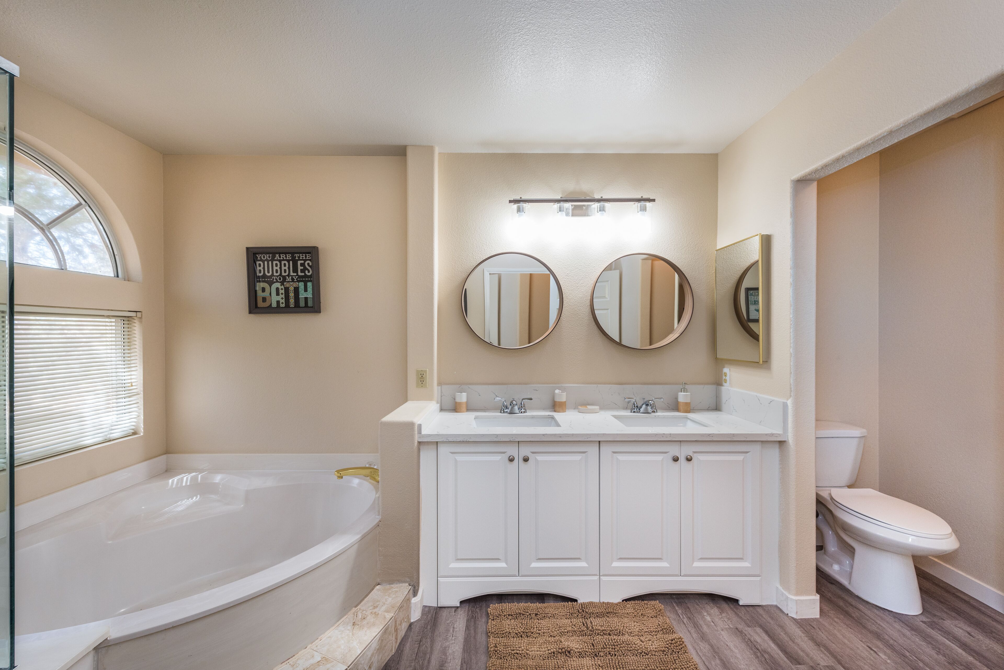 Une salle de bain avec une baignoire, deux lavabos et des toilettes.