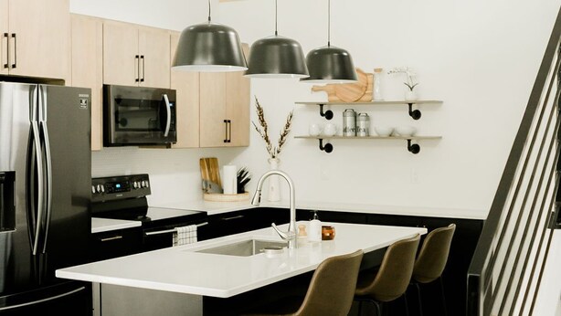 Eine moderne Küche mit einer zentralen Kochinsel, Edelstahlgeräten und einem minimalistischen Design.