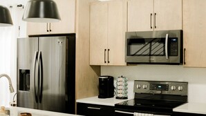 Eine moderne Küche mit Edelstahlgeräten, darunter ein Kühlschrank, eine Mikrowelle und ein Backofen.