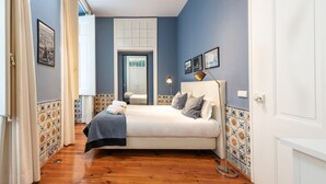 Une chambre à coucher avec un lit, une lampe de chevet, un miroir et une porte.