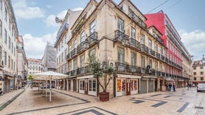Un bâtiment historique à étages, doté de balcons et d’un sol recouvert de carreaux.