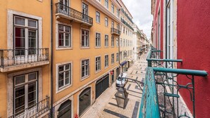 Une rue étroite, bordée de bâtiments des deux côtés, avec des balcons et un chemin pavé.