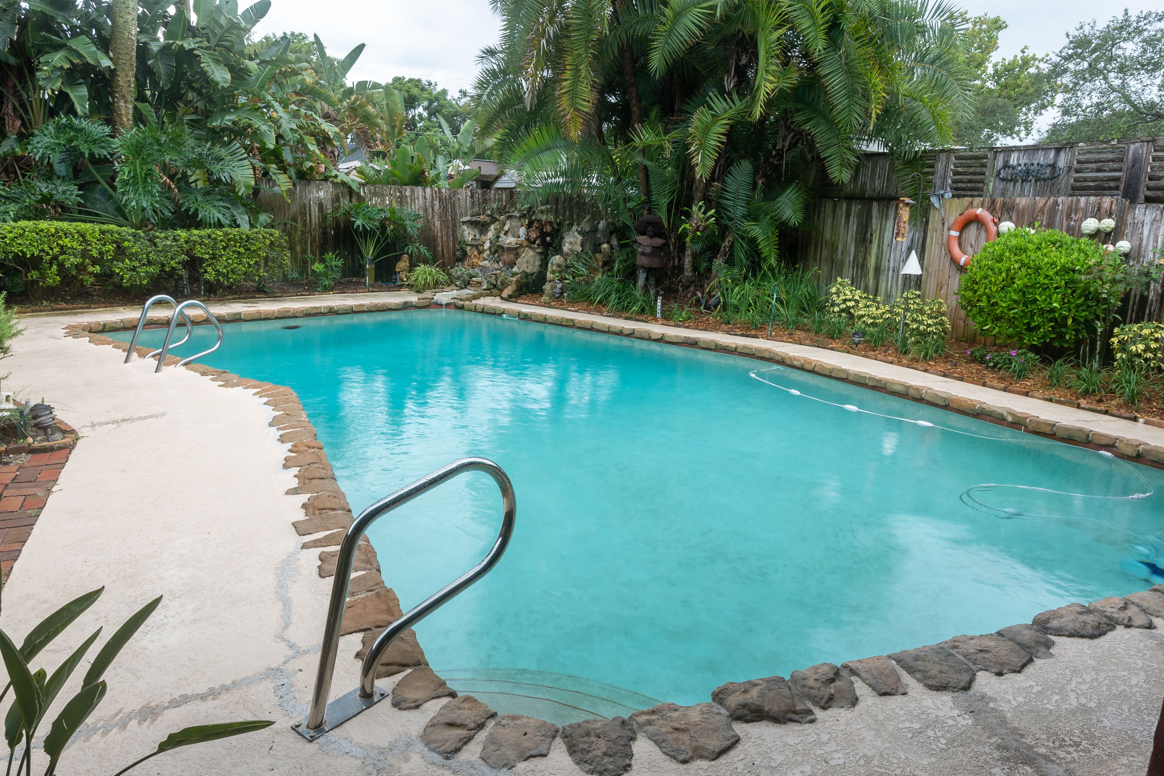 Large living area, tropical backyard with swimming pool & covered  back porch