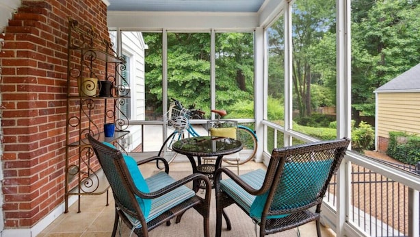 A covered patio with wicker furniture and a bicycle.