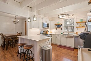 Enjoy cooking in this well-equipped kitchen with a central island and stainless steel sink.