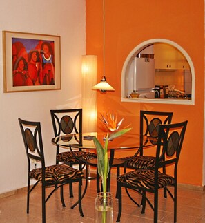 Enjoy meals in this stylish dining area with a round table and pendant light, surrounded by a geometric-patterned chair set.
