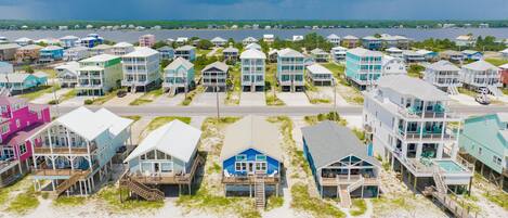 A coastal residential area with beachfront properties featuring balconies, some with pool access.