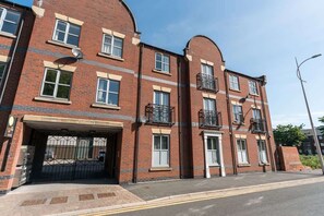 A multi-story brick building with a gated entrance, multiple windows, and balconies. - Stylish Hull Apt - City Centre & Gated Parking (Hull)
