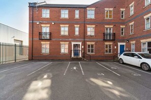 A multi-story brick building with a parking area in front. - Stylish Hull Apt - City Centre & Gated Parking (Hull)