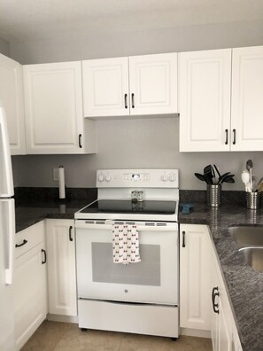 Kitchen features an oven, microwave, and stainless steel sink.