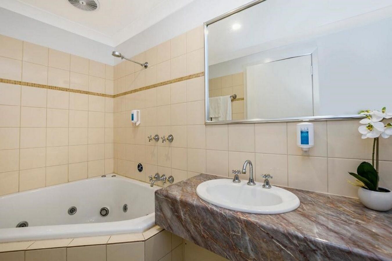 A bathroom with a bathtub, a sink, and a mirror.