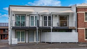 A modern two-story building with a balcony, large windows, and a flat roof. - Apartments 521 (Warrnambool)