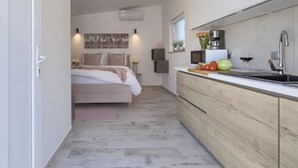 Ein modernes Schlafzimmer mit einem Bett, Nachttischen und einer Wand-Klimaanlage.