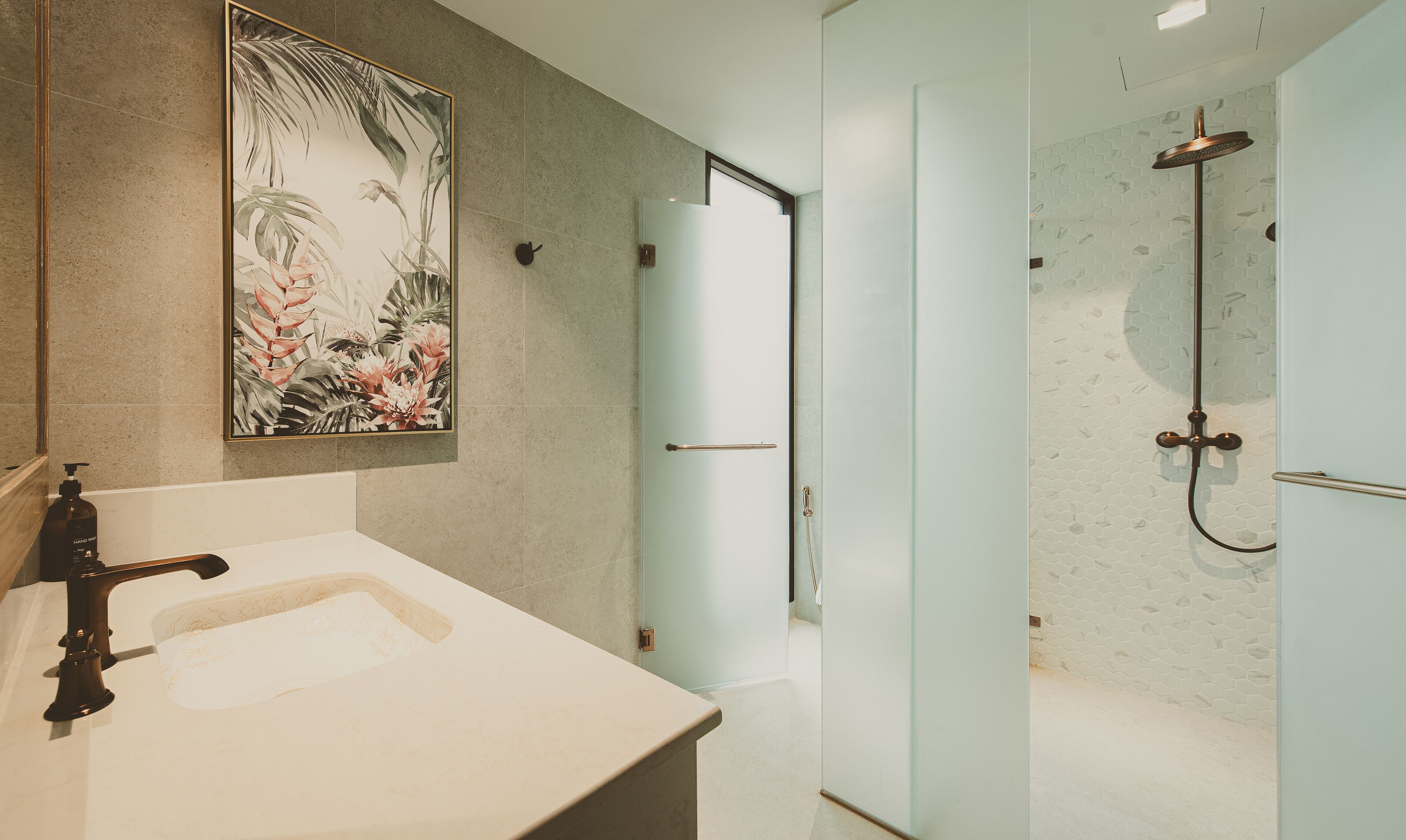 A modern bathroom with a marble sink, a glass shower enclosure, and a large floral artwork on the wall.