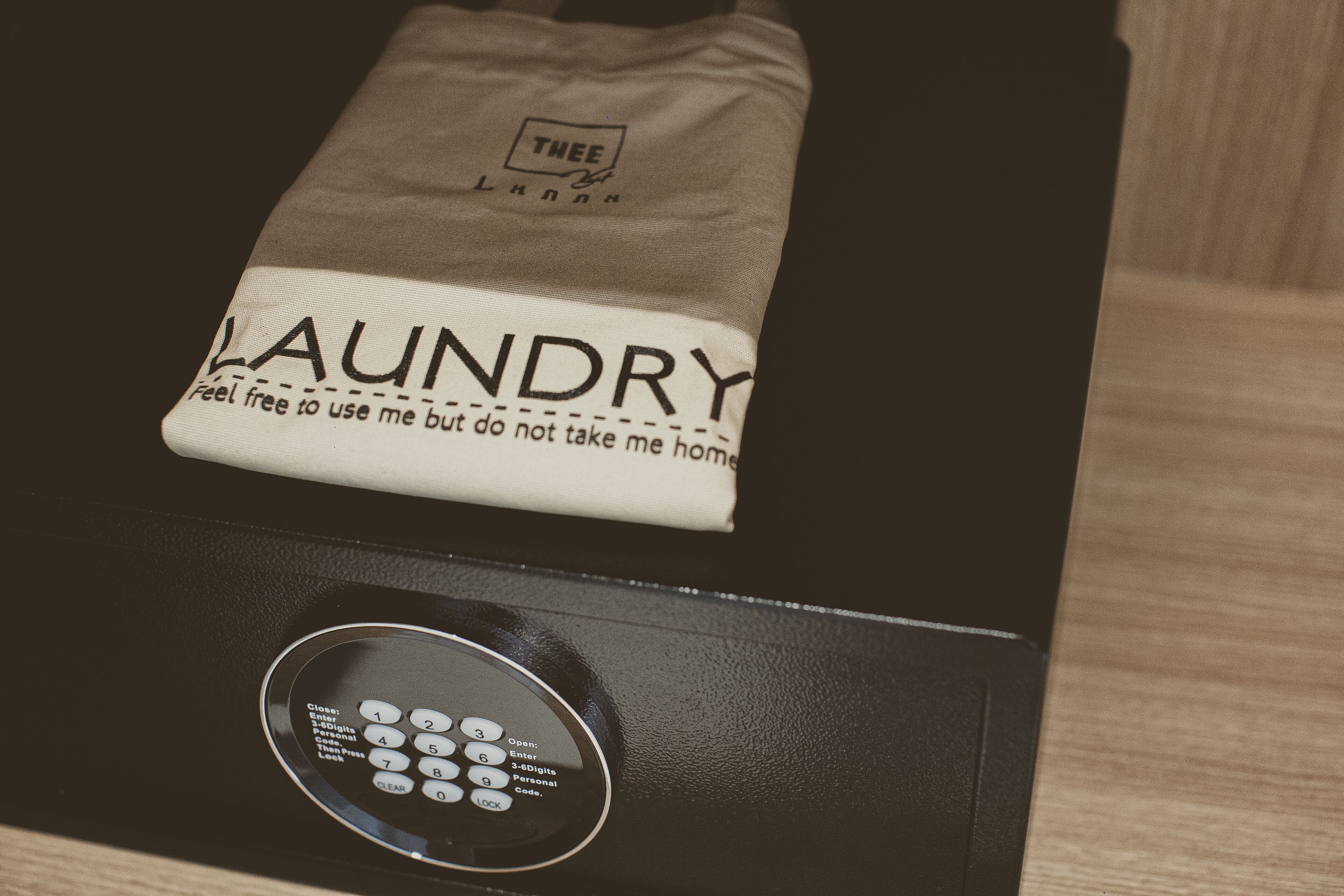 A black appliance with a control panel and a cloth with "LAUNDRY" and "feel free to use me but do not take me home" printed on it.