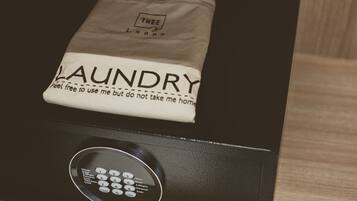 A black appliance with a control panel and a cloth with "LAUNDRY" and "feel free to use me but do not take me home" printed on it.
