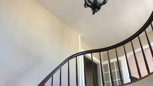 Una imponente escalera con barandilla de madera y balaustradas blancas que conduce a un piso superior.