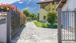 Un chemin de pierres mène à un bâtiment jaune, avec une montagne en arrière-plan.