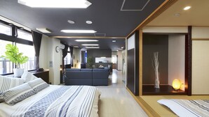 Une chambre d’hôtel moderne dotée d’un grand lit, d’un canapé, d’un coin repas et offrant une vue sur la ville.