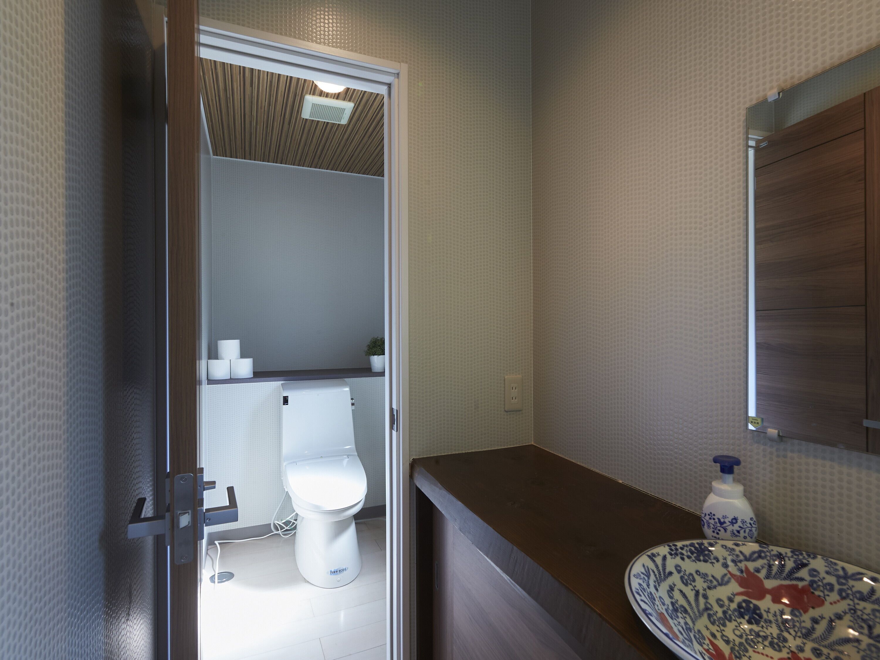Ein modernes Badezimmer mit Toilette, Waschbecken und Spiegel.
