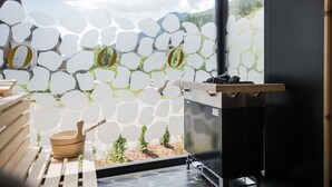 Une cuisine moderne avec un mur en pierre, des ustensiles en bois et une vue sur l’extérieur.