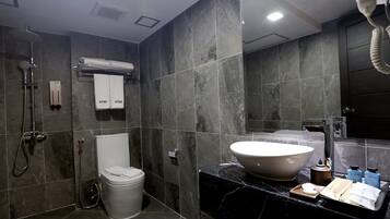 A modern bathroom with a large sink, a toilet, and a shower area.
