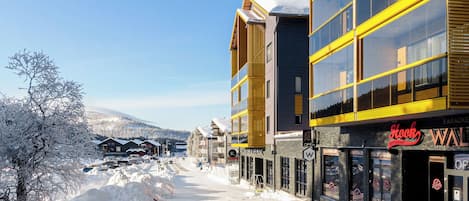A snow-covered street with buildings, including a restaurant named 'Hook Restaurant'.