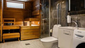 A modern bathroom with a wooden vanity, a toilet, a shower, and a Samsung washing machine.