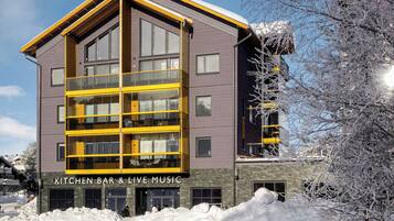 A multi-story building with a modern architectural design, featuring a prominent yellow and grey color scheme.