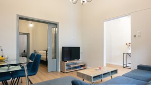 Una sala de estar moderna con televisor, sofá y comedor.