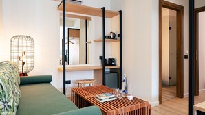 Una sala de estar moderna con un sofá verde, una mesa de centro de madera y un espejo grande.