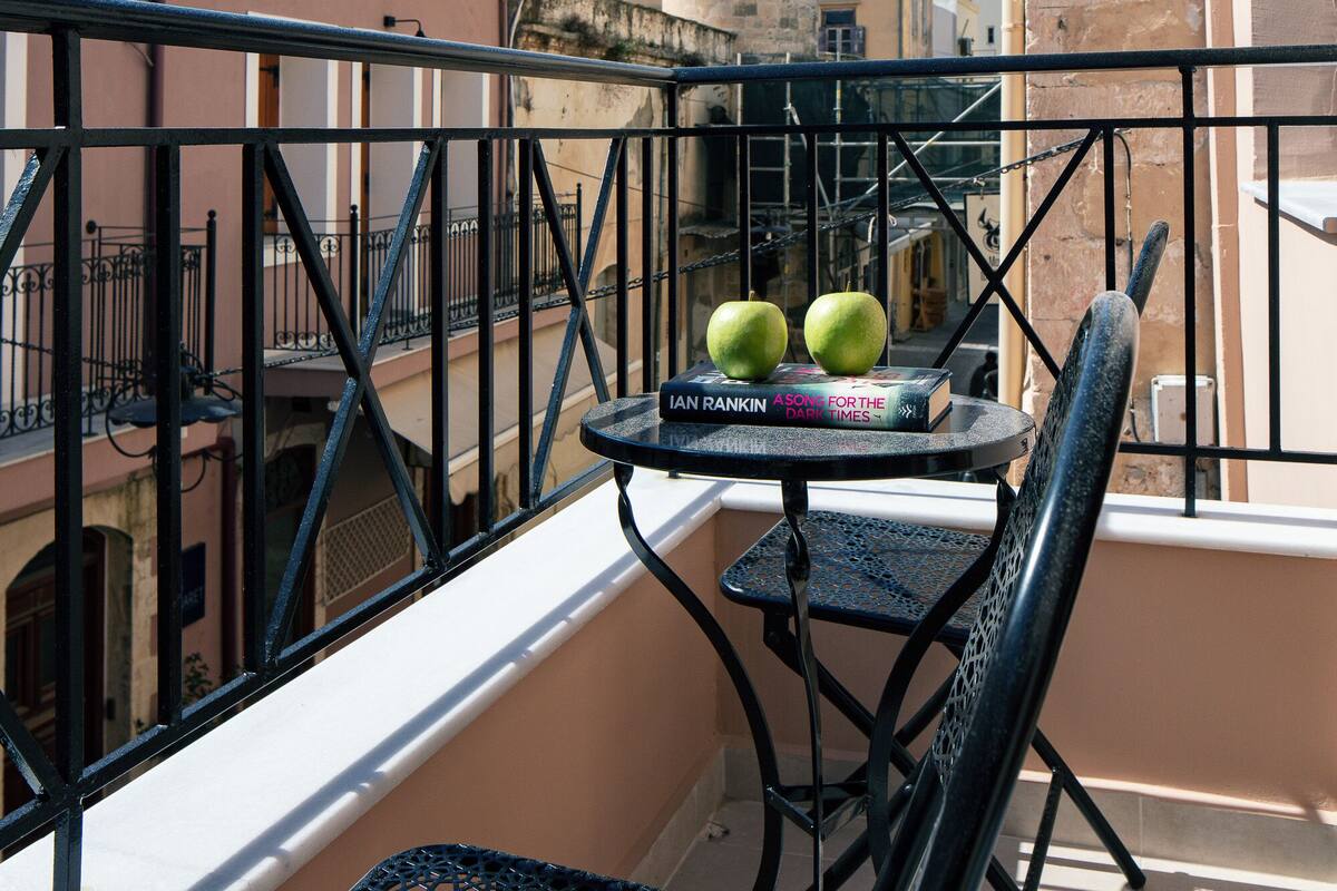 A balcony with a table, two apples, and a book titled "Ian Rankin For the Times".