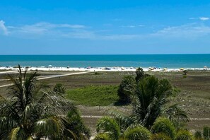 A beach with a clear view of the ocean and a sandy shore.