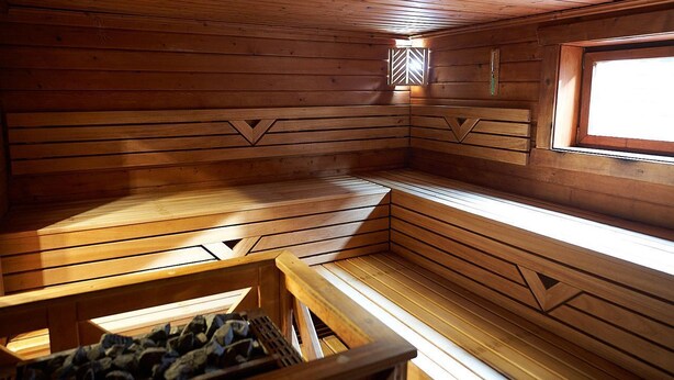 Una sauna con bancos de madera y techo inclinado.