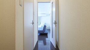 A narrow hallway with a bed at the end. - Oyado Kinokuniya Daikoku Machi (Nagasaki)