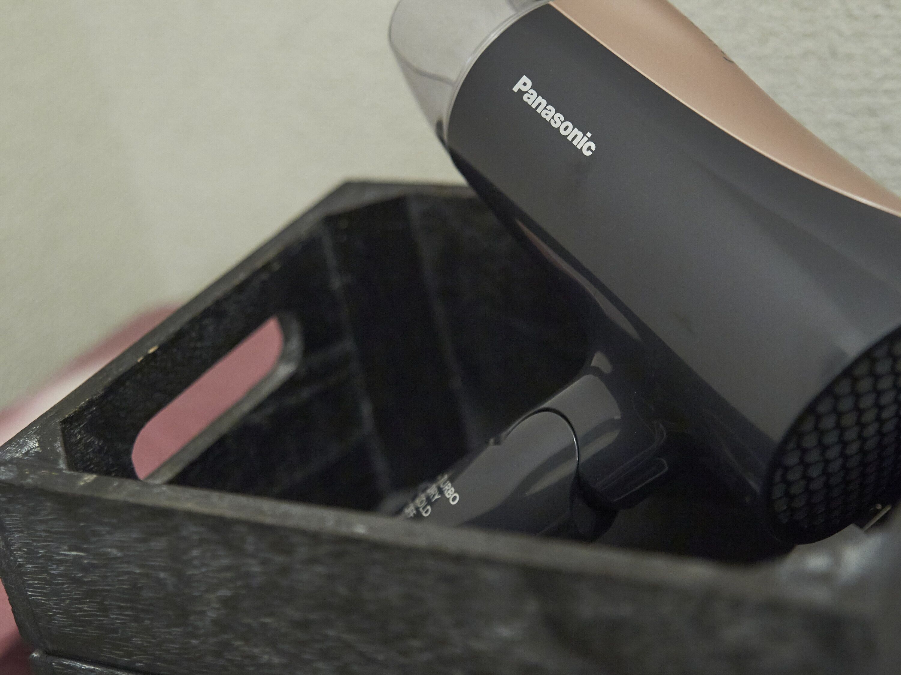 A Panasonic hair dryer in a black case with a pink handle.
