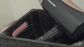 A Panasonic hair dryer in a black case with a pink handle.